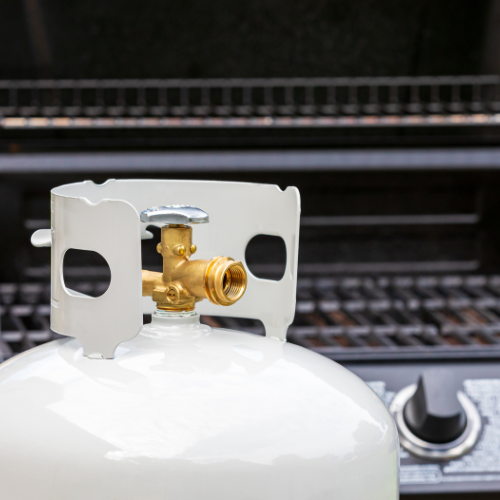 Propane tank in front of a propane grill